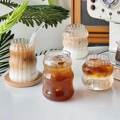 three different types of drinks sitting on a table next to an espresso machine