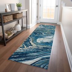 a blue area rug with white swirls on it in front of a wooden floor