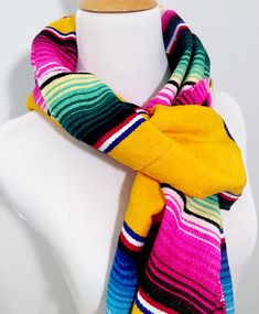 I've turned a traditional Mexican serape into a warm, comfy Mexican scarf. Made from an authentic Mexican serape, each scarf wrap is 78 inches long and 9 inches wide. Each end is finished with 3.5 inch long fringe. It can be wrapped around your neck several times for added warmth. It can be draped across your shoulders, tied at your throat or held in place with a simple knot. I finished off the edges with a coordinating thread in a zigzag pattern. Traditional Multicolor Scarves For Winter, Traditional Multicolor Winter Scarves, Traditional Multicolor Winter Scarf, Hippie Multicolor Scarf One Size, Multicolor Bohemian Poncho With Scarf, Bohemian Multicolor Poncho With Scarf, Traditional Multicolor One Size Scarves, Traditional Multicolor Scarves One Size, Traditional Multicolor Scarves