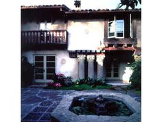 an old house with a fountain in the front yard