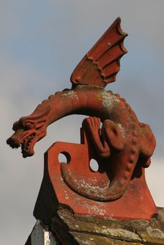 a red dragon statue on top of a building