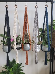 there are several hanging planters with plants in them