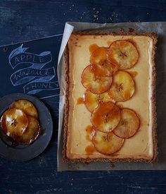 an apple tart is on the table next to a plate with some pies