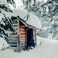 an old log cabin is covered in snow