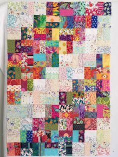 a colorful patchwork quilt hanging on the wall