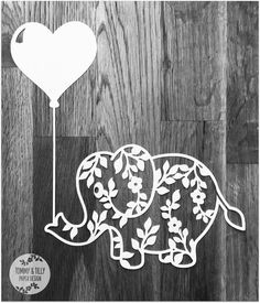 an elephant holding a heart shaped balloon on top of a wooden floor with leaves and vines