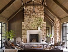 a living room filled with lots of furniture and a fire place in the middle of it