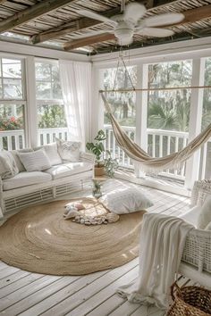 a living room with white furniture and lots of windows