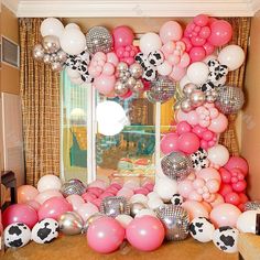 the balloon arch is decorated with pink, white and black balloons for a cow theme