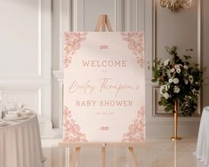 a welcome sign for a baby shower is on an easel in the middle of a room