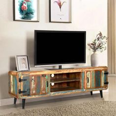 an entertainment center with a television and pictures on the wall