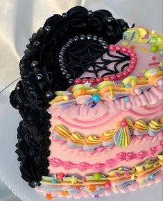 there is a large cake decorated with black and pink icing