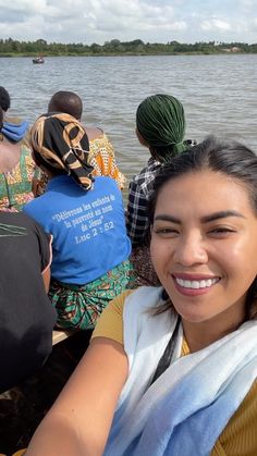 a group of people riding on top of a boat in the water with one woman smiling at the camera