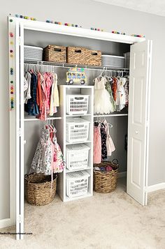 an organized closet with clothes, baskets and toys on the shelves in front of it