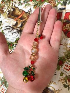 a person's hand holding a pair of scissors with beads and bells on it