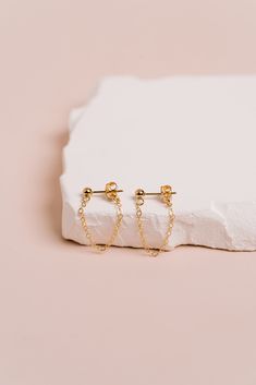 D E T A I L S  Simple and beautiful, these chain earrings are dainty and perfect for everyday wear. 3mm ball studs with attached chain ear jackets.   Choose from 2 styles:  cable chain or lacie chain. Created in 14K Gold Fill & Sterling Silver.   Sold as a pair of 2 earrings.  Includes ball studs with chain ear jackets and matching 14k Gold-Filled backings Handcrafted in our San Clemente studio. Video shows the cable chain studs. S I Z E     I N F O   3mm ball studs  Chain dangle measures 1.5" Gold Chain Earrings, Dainty Hoop Earrings, 2 Earrings, San Clemente, Gold Filled Earrings, Metal Earrings, Rose Earrings, Rose Gold Earrings, Chain Earrings