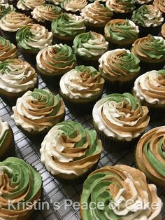 cupcakes with green and white frosting sitting on a cooling rack