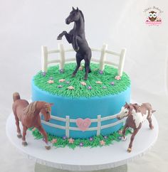 there is a cake with horses on the top of it and frosting in the shape of a horse jumping over a fence