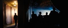 silhouettes of people standing in front of a doorway