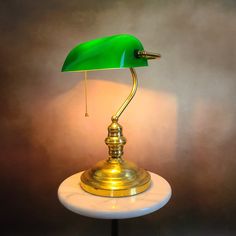 a green lamp sitting on top of a white table