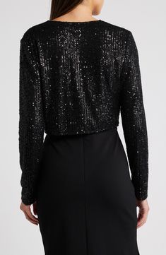 Sequins sparkle under the lights on a long-sleeve bolero that will add old Hollywood glamour to your evening look. Front hook-and-eye closures V-neck Long sleeves 95% polyester, 5% spandex Hand wash, line dry Imported Winter Party Fitted Shrug, Elegant Winter Shrug For Night Out, Glamorous Evening Tops For Winter, Glamorous Winter Evening Tops, Glamorous Evening Winter Tops, Fitted Evening Shrug For Fall, Winter Evening Fitted Shrug, Elegant Party Shrug For Fall, Elegant Fall Party Shrug