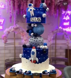 a three tiered cake with space themed decorations