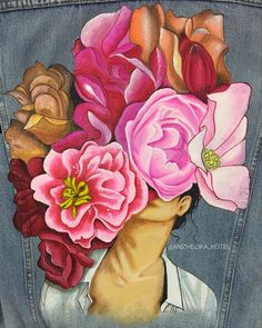 a painting of a woman's head with flowers in her hair on a jean jacket