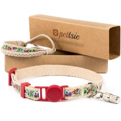 a white dog collar with colorful flowers on it and a red plastic ring around the collar