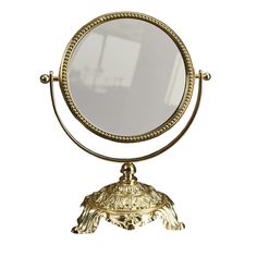 an ornate gold mirror on a stand against a white background