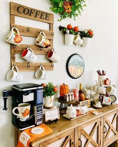 a coffee bar is decorated with pumpkins and other fall decorations, including mugs hanging on the wall