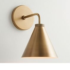 a light that is on the wall next to a white wall with a brown shade