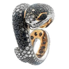 While most snakes carry a deadly bite, the Sweet Venom ring, a Zorab Creation, was designed to deliver a much more seductive lure. 3.30 carats of black diamonds blend with 4.07 carats of white diamonds set with 0.72 carats of spinel, all scaled to captivate temptation. While most won't want to remove this snake's gentle finger hug, when you do, the gleaming 18-karat gold and palladium underbelly will make your new pet as enticing off as it will be on. This ring, as with any genuine Zorab Creation, is sent with a serial number to validate its authenticity. Venom Design, Sweet Venom, Black White Diamond Ring, Argentium Silver Jewelry, Sapphire Cocktail Ring, Twisted Ring, Snake Jewelry, Gold Cocktail Ring, White Diamond Ring