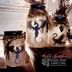 three jars with some type of creature painted on them