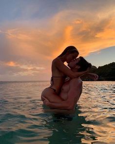 a man and woman are kissing in the water