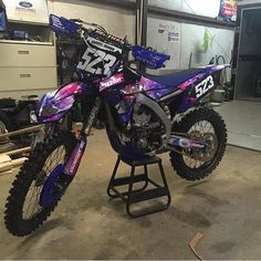 a purple dirt bike parked in a garage