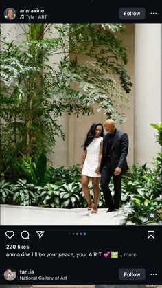 a man and woman standing next to each other in front of some plants on the ground