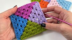 a woman is crocheting squares in different colors with a pink crochet hook