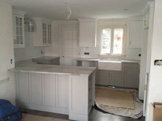 a kitchen with white cabinets and an island in the middle is being remodeled to make room for new appliances