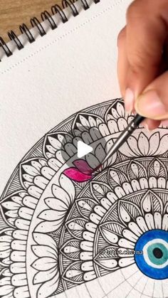 someone is drawing an eye on a piece of paper with colored pencils and markers