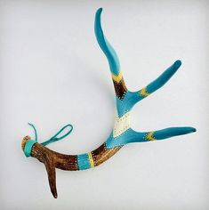 a blue and brown bird made out of wood with an ornament on it's body