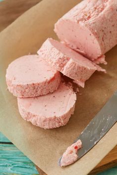 there are three pieces of pink cake on the table next to a knife and paper bag