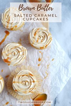 cupcakes with caramel icing on white paper next to jar of caramel sauce