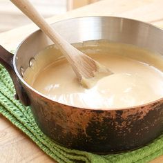 a wooden spoon in a pot on a green towel