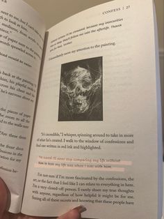 someone is holding an open book in their hand and it has a skull on the page