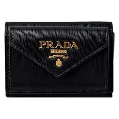 Fashion meets function with the Prada Vitello Black Leather Envelope Tri-fold Wallet. Crafted from luxurious black vitello leather, this durable wallet is ideal for everyday use. The compact trifold design includes multiple card slots, a bill compartment, and an exterior snap pocket. Finished with the iconic Prada logo plaque in gold for an elevated touch, this chic wallet will make a classic addition to your collection. Model: 1MH021 Black vitello leather Prada logo plaque Gold-tone hardware Tr Designer Compact Wallets With Card Slots, Designer Compact Wallet With Card Slots, Designer Business Trifold Wallet, Luxury Compact Wallet With Coin Pocket, Designer Trifold Wallets For Formal Occasions, Luxury Black Trifold Wallet With Coin Pocket, Luxury Leather Trifold Wallet For Evening, Black Wallets With Logo Plaque For Everyday Use, Elegant Compact Trifold Wallet With Coin Pocket