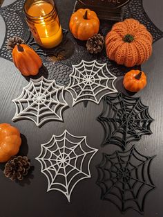 halloween decorations on a table with candles and pumpkins in the center, surrounded by spider webs