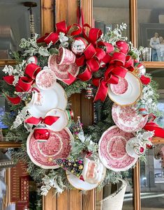 a christmas wreath with red bows and plates