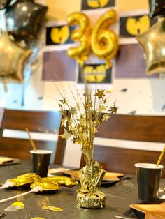 the table is set for a celebration with gold confetti and star shaped balloons