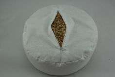 a white round pillow with an embroidered design on it