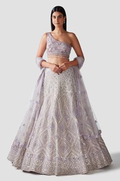 Lilac organza lehenga with geometric motifs adorned with gota, mirror, resham , sequins and crystals. Comes with a one shoulder blouse and a mirror work bordered dupatta.
Component: 3
Pattern: Embroidery
Type Of Work: Dabka, Sequins, Pipes and Crystals
Neckline: One shoulder
Sleeve Type: Sleeveless
Fabric: Lehenga and Blouse: Organza; Dupatta: Net
Color: Purple
Other Details: 
Tassel details
Mirror work border dupatta
Occasion: Destination Wedding,Bride - Aza Fashions American Indian Dress, Blouse Organza, Lehenga And Blouse, Purple Lehenga, Net Embroidery, Organza Lehenga, Embroidered Lehenga, Lehenga Blouse, Geometric Motifs